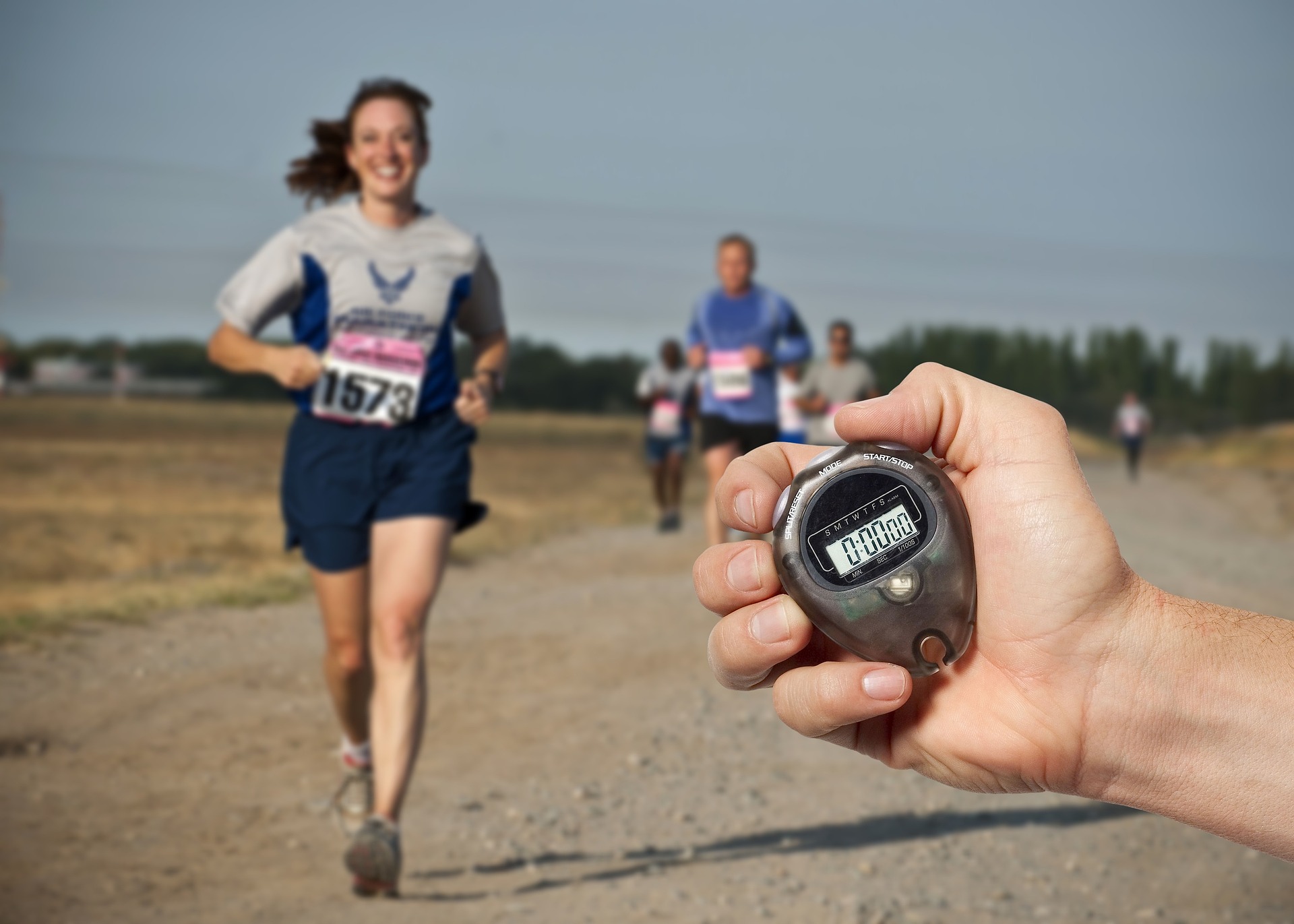 A stopwatch timing runners during an outdoor running session